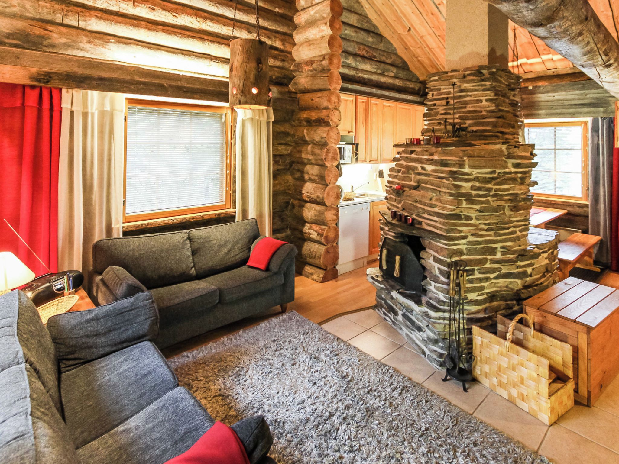 A cozy living room with a stone fireplace, a sofa, and a dining area.