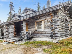 A log cabin with a porch, a chimney, and a window with shutters. - Kuruhovi b by Interhome (Kuusamo)