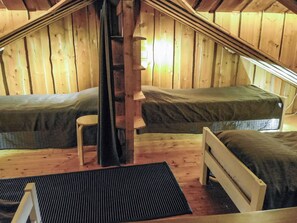 A cozy attic bedroom with two single beds, a small chair, and a ladder. - Kuruhovi b by Interhome (Kuusamo)