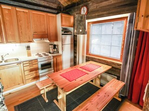 A compact kitchen with wooden cabinets, a stove, an oven, and a refrigerator.
