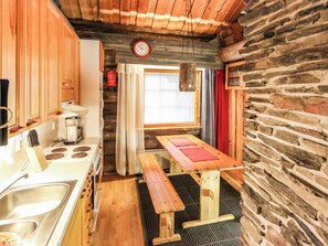 Una cocina compacta con armarios de madera, estufa y lavamanos.