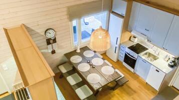 A compact kitchen with a dining area, a clock, and a window.