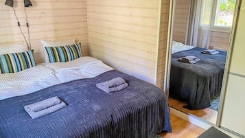Una habitación con una cama, un espejo y una ventana.