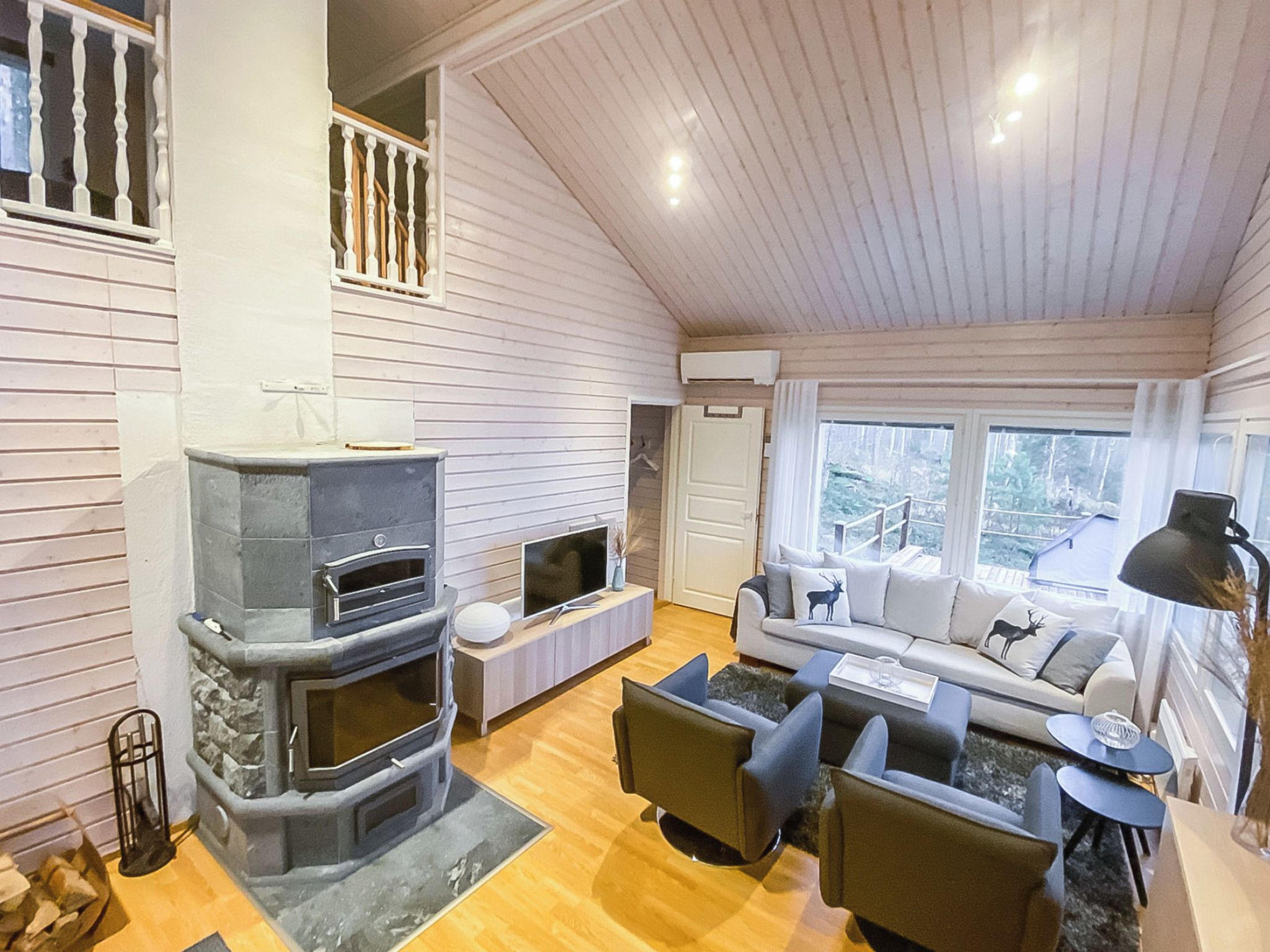 Una sala de estar acogedora con chimenea, un conjunto de sofás y una televisión.