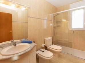 A bathroom with a sink, toilet, and glass-enclosed shower. - Eurosol by Interhome (Miami Platja)