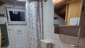 Casa de banho compacta com sanita, lavatório e zona de duche.
