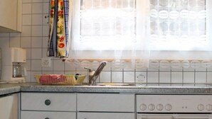Een keuken met een spoelbak, fornuis en kastjes.