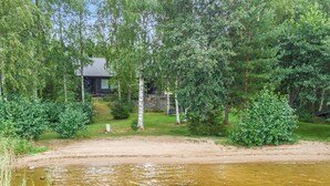 A lakeside cabin with a sandy beach and dense greenery. - Runoniekka by Interhome (Rautalampi)