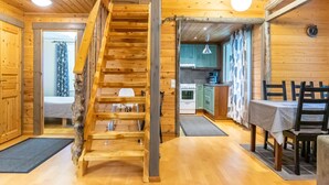 A wooden interior with a staircase, a dining area, and a kitchen. - Runoniekka by Interhome (Rautalampi)