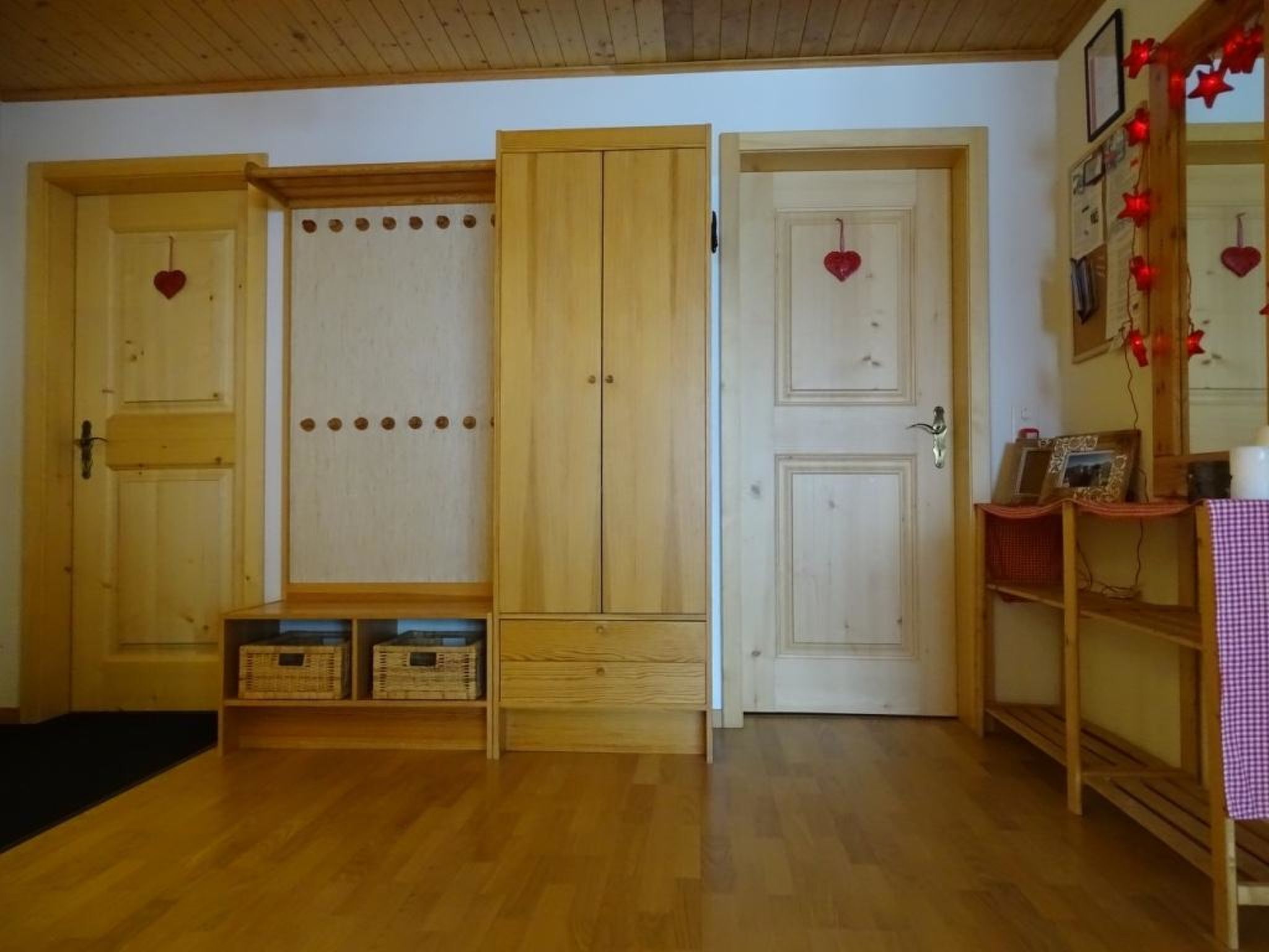 A room with wooden doors, a bench, and a small table with a checkered tablecloth.
