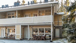 Ein zweistöckiges Holzhaus mit einer Veranda und einem Schotterweg.