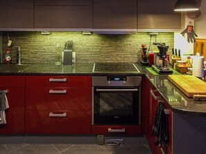 Een koelkast, een magnetron, een vaatwasser, kookgerei, borden en bestek