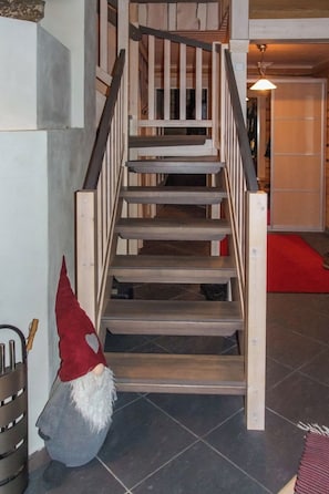 Un escalier en bois orné d’une figurine de gnome à sa base.