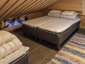 A cozy attic bedroom with a bed, a bench, and a small table. - Seppola by Interhome (Kuusamo)