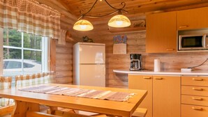 Cocina de cabaña de madera con refrigerador, cafetera y microondas.