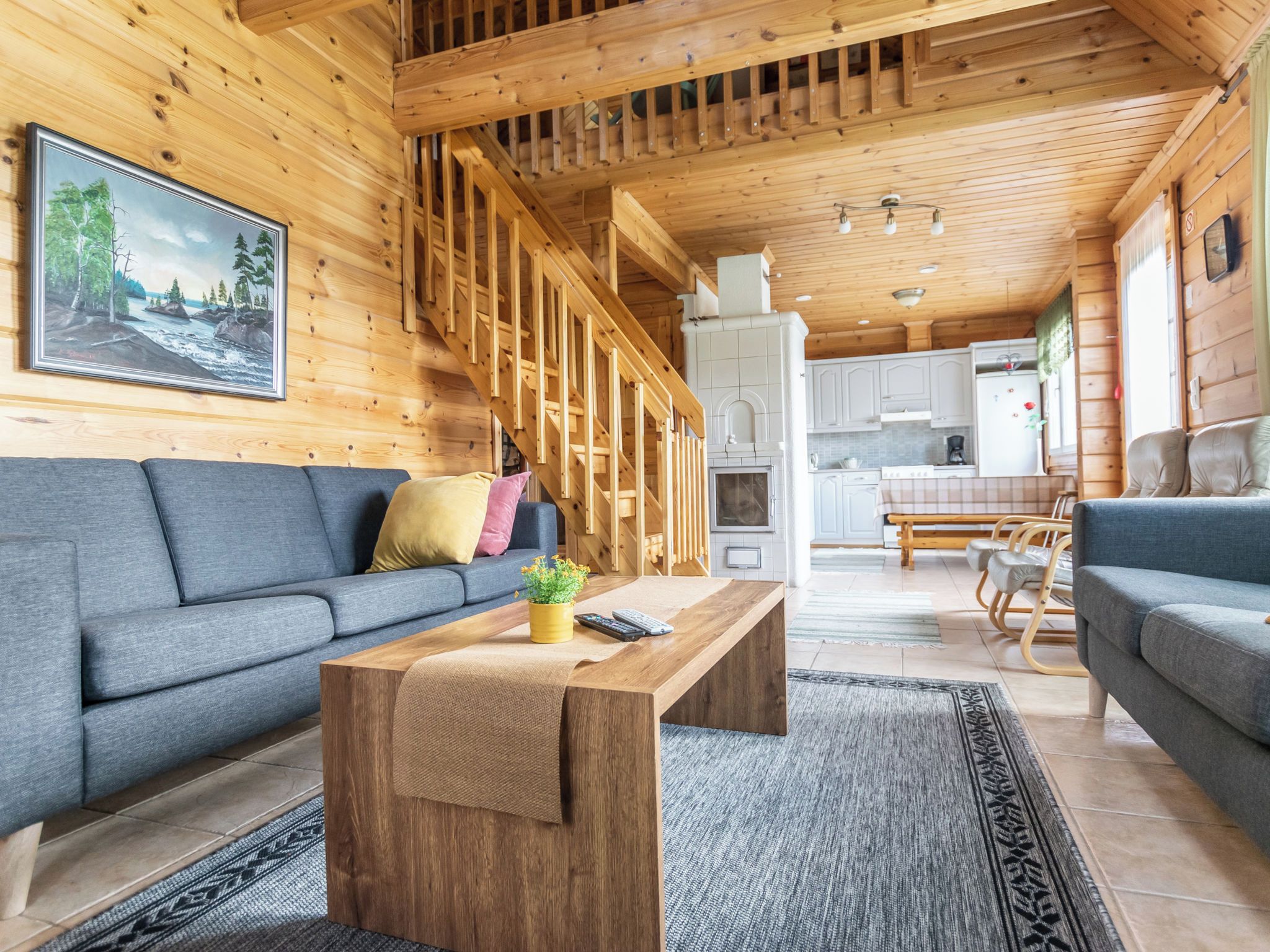 Un intérieur en bois comprenant un canapé, une table basse et un coin cuisine.