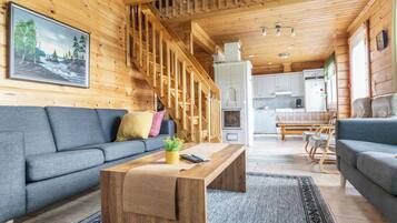 Un intérieur en bois comprenant un canapé, une table basse et un coin cuisine.