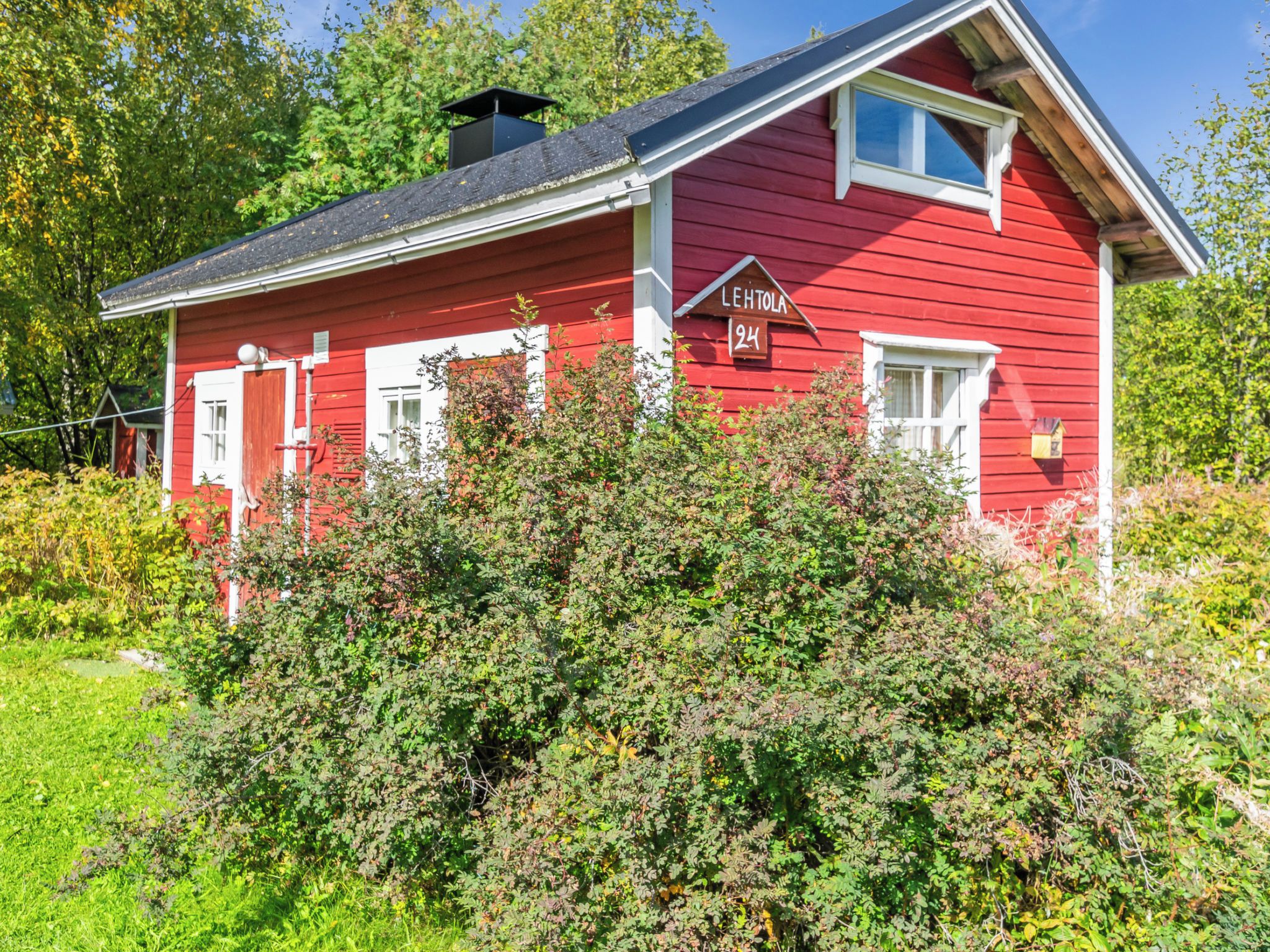 A red wooden house with a number '24' and the name 'LEHTOLA' on the side.