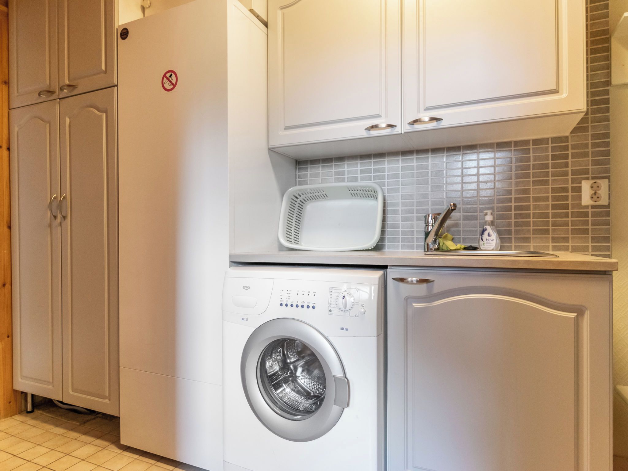 A compact laundry area with a washing machine, a dryer, and a microwave.
