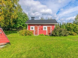 A red house with a sloped roof, a chimney, and a front door.