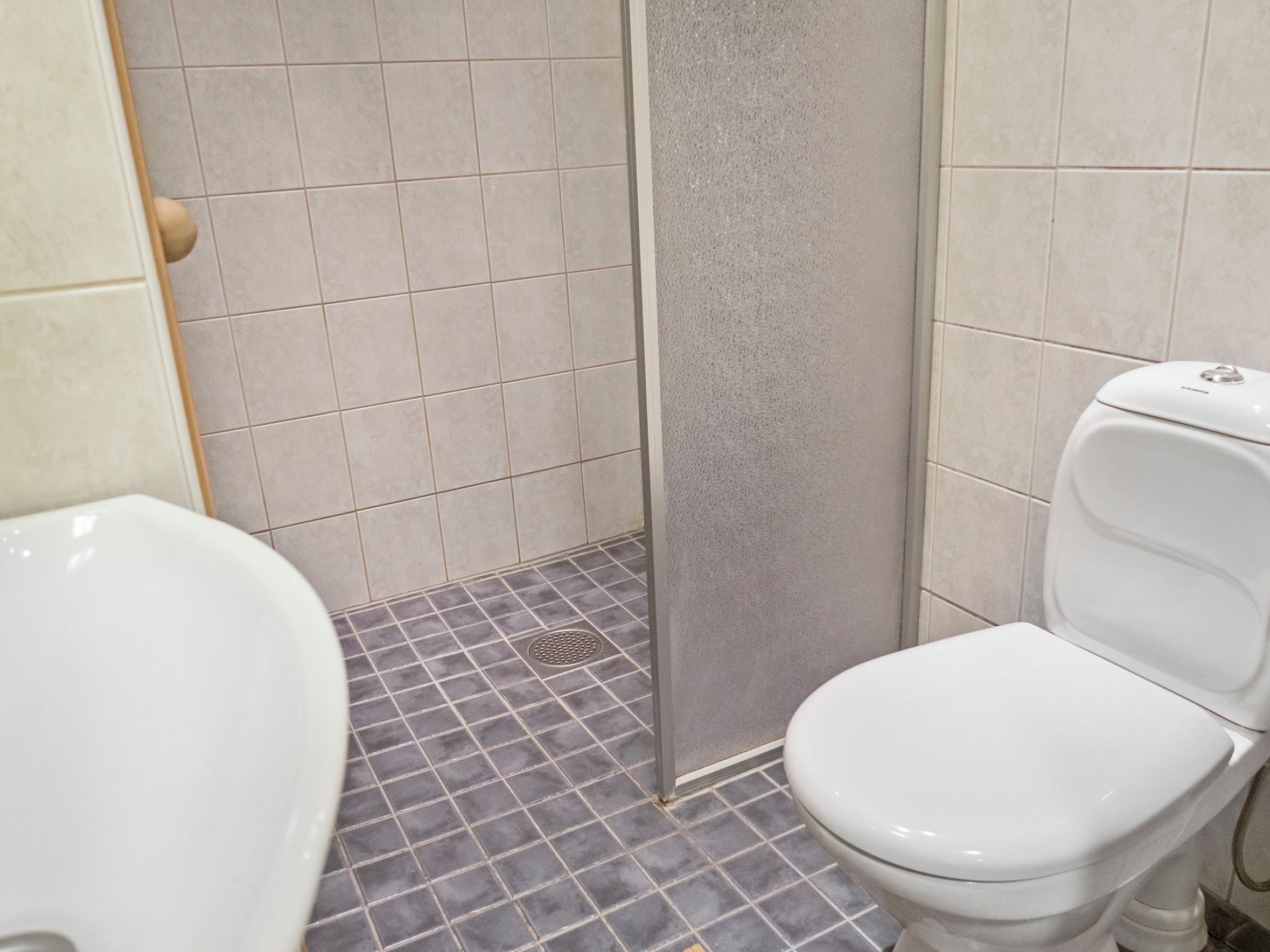 Ein Badezimmer mit Toilette, Waschbecken und Duschbereich.
