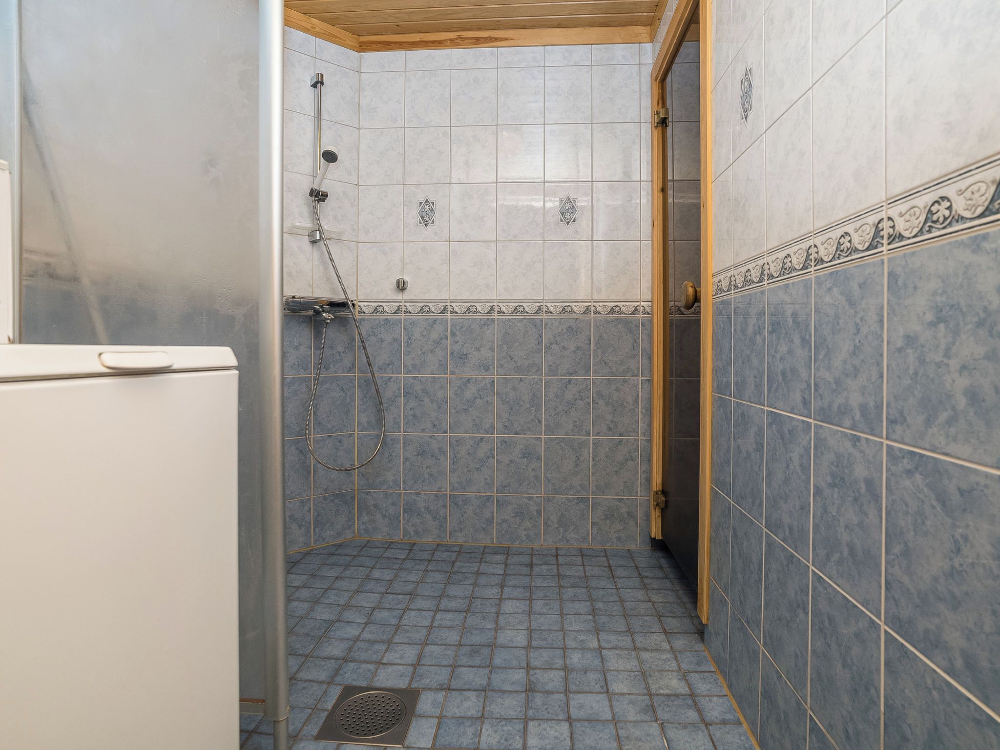 A small, tiled bathroom with a shower, a toilet, and a sink.