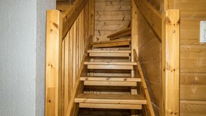 A wooden staircase with a brick wall behind it.