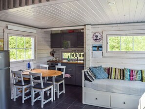 A compact kitchen with a dining area, a sofa, and a window with a view. - Lekojärven herra by Interhome (Äänekoski)