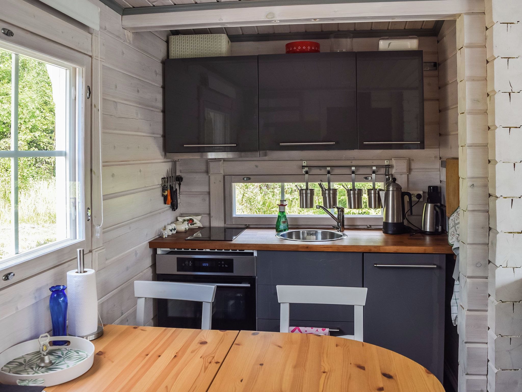 Una cucina compatta con un tavolo di legno, un lavandino e una finestra.