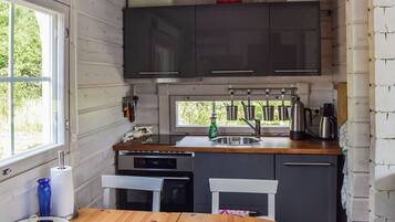 Una cucina compatta con un tavolo di legno, un lavandino e una finestra.