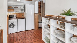 A compact kitchen with a washing machine, microwave, and refrigerator. - Satakieli by Interhome (Somero)