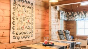 A wooden interior with a long table, two chairs, and a decorative wall hanging. - Varvali by Interhome (Konnevesi)