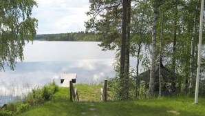 A lakeside cabin with a wooden deck and a small shed. - Varvali by Interhome (Konnevesi)