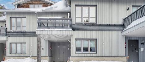 Ein zweistöckiges Gebäude mit Balkon, einem Hydranten und der Nummer 5 an der Tür.