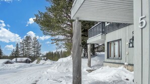 A snow-covered property with a wooden structure, numbered 5, and a clear sky.
