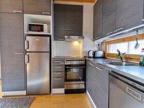 Een moderne keuken met roestvrijstalen apparatuur, waaronder een koelkast, magnetron, oven en vaatwasser.