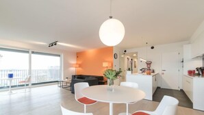 Um apartamento moderno com área de jantar, cozinha e sala de estar.