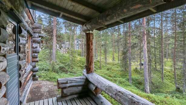 Eine Holzterrasse mit Blick auf einen Wald.