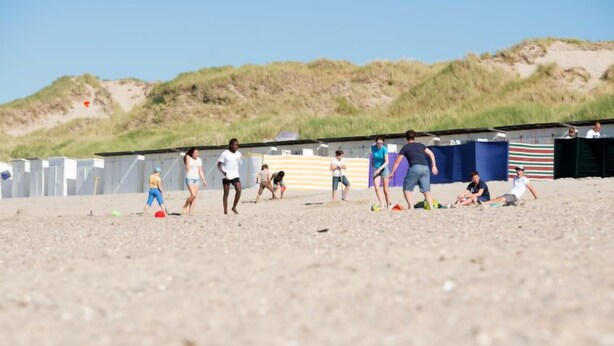 A beach with people playing and a structure in the background. - Zeeparel 402 with balcony by Interhome (Bredene)