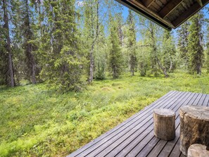A wooden deck with a view of a forested area.