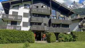 Un hôtel à plusieurs étages, doté de balcons, situé dans un cadre montagneux.