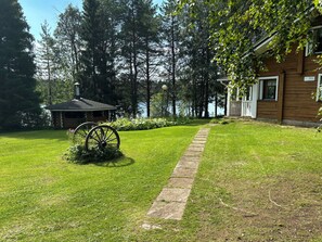 A wooden cabin with a stone pathway leading to a wooden dock.