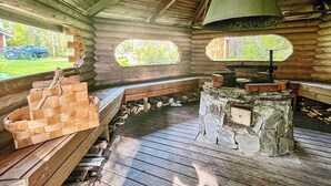 Ein rustikales Blockhaus-Interieur mit einer Holzbank, einem Steinkamin und einem Schornstein.