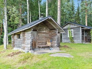 A rustic cabin with a sloped roof, a chimney, and a small porch.