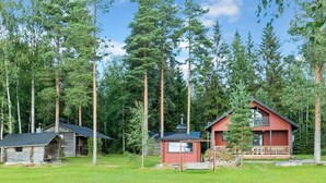 Une cabane dotée d’un petit porche et un bâtiment séparé avec un porche plus grand.