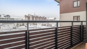 Un balcon donnant sur un paysage enneigé et des bâtiments.