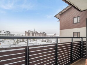 A balcony with a view of a snow-covered landscape and buildings.