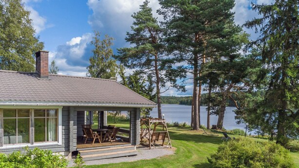 A house with a covered porch, a dining area, and a view of a lake. - Katajainen by Interhome (Ikaalinen)