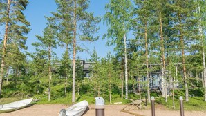 A lakeside property with a dock, boats, and a forested area.