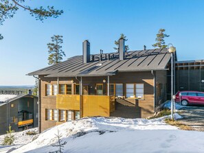 A modern two-story house with a sloped roof, large windows, and a visible chimney. - Karhunvartijan kota b1 by Interhome (Kuusamo)